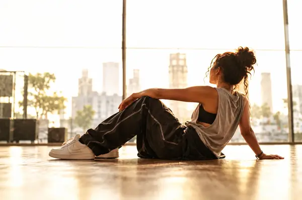 Hip-Hop Beat: a dancer resting in a bright urban rehearsal space